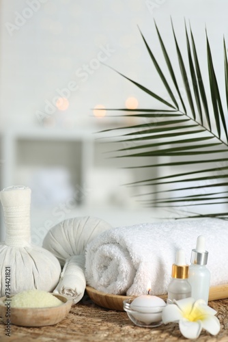 Composition with different spa products and plumeria flower on wicker mat indoors