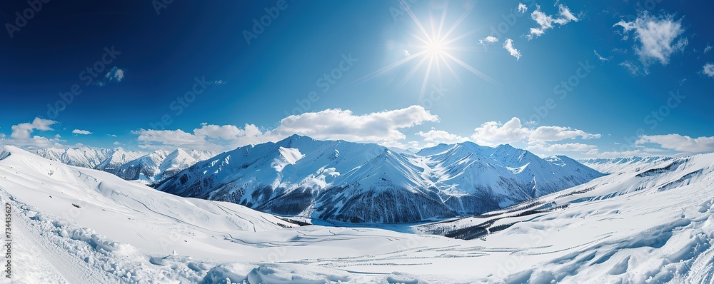 View of snowy mountains with clear blue sky and white clouds in winter