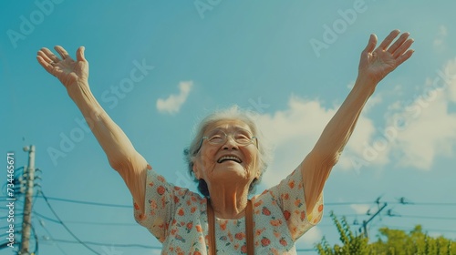 Waist up shot of happy elderly woman with hands in the air © Jennifer