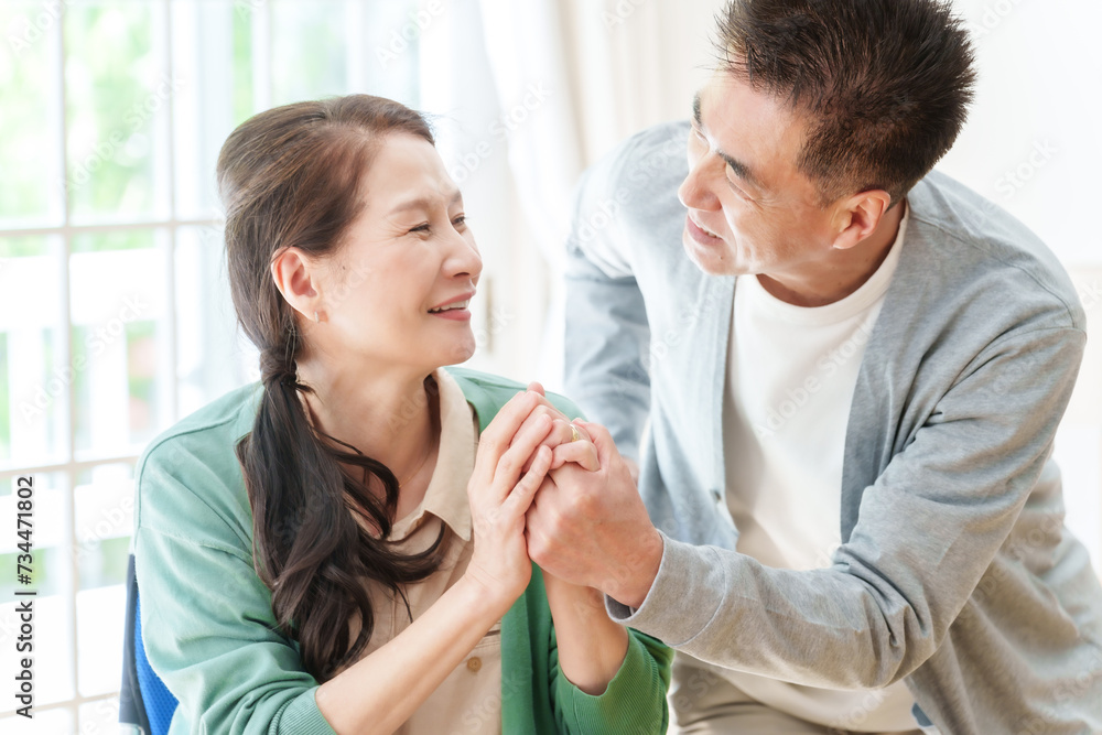 車椅子に乗った妻の手を握る夫 車椅子に乗った妻の手を握る夫