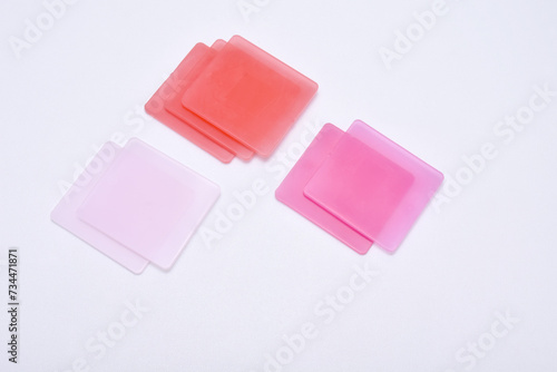 pink color chips isolated on a white background, these chips are examples of product colors produced by masterbatch in the plastics industry