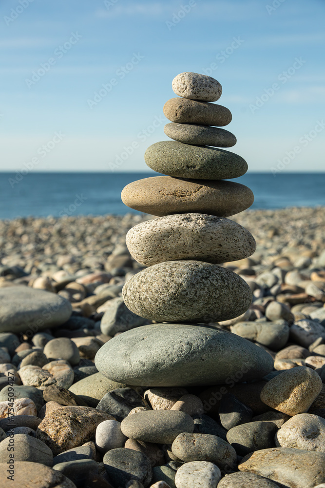 Pyramid of round gray stones on the bank of a mountain river. Zen and harmony concept.Stone tower Pyramid of round gray stones on the bank of a mountain river. Zen and harmony concept.Stone tower