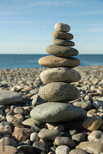 Pyramid of round gray stones on the bank of a mountain river. Zen and harmony concept.Stone tower