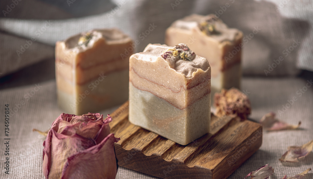 Delicate pieces of natural floral soap made from safe, eco friendly organic ingredients in a wooden soap dish. A beautiful postcard Delicate pieces of natural floral soap made from safe, eco friendly organic ingredients in a wooden soap dish. A beautiful postcard
