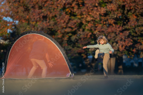 Child boy football or soccer player in action on football stadium kicking football ball for goal. Concept of sport, competition. Kid kick football ball. Kid kicking soccer ball. Sport for kids.