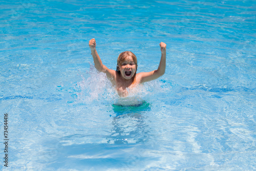 Kid playing in pool. Summer holidays and vacation concept. Happy child playing in the sea or swimming pool water. Summer vacation and healthy lifestyle concept. Cute child splash water at pool.