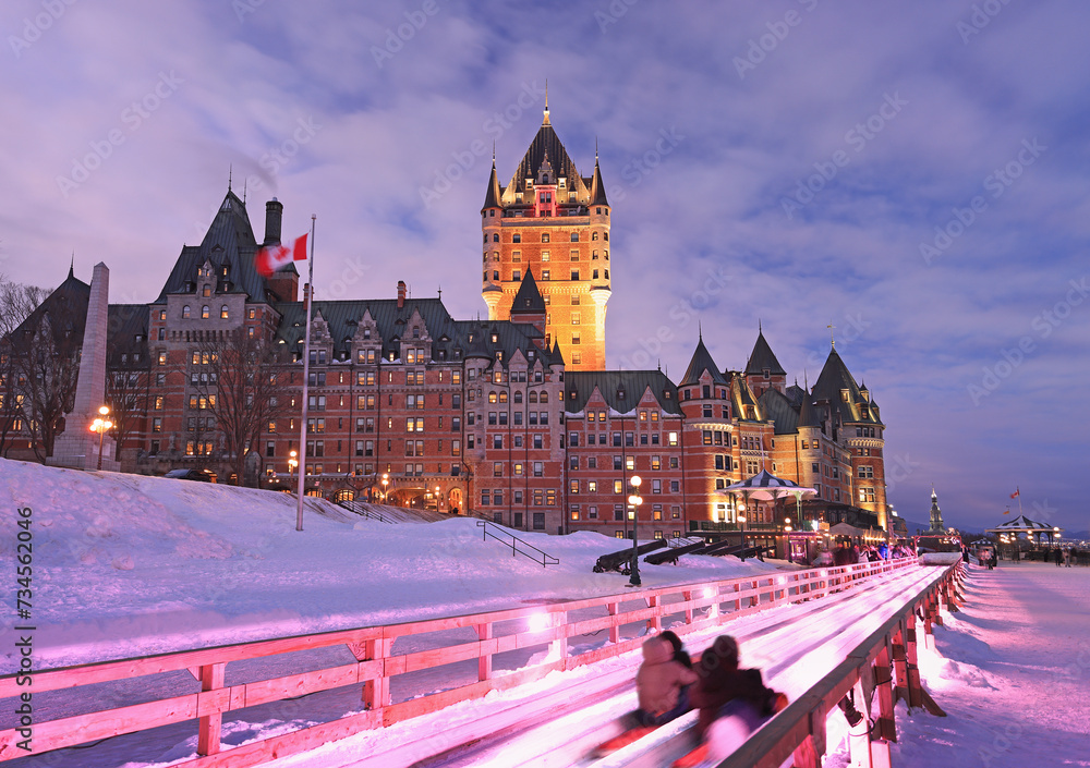 Naklejka premium Traditional slide descent in winter in Quebec City with Frontenac Castle illuminated at dusk