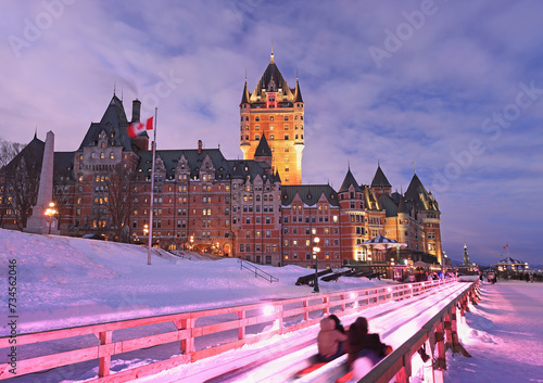 Traditional slide descent in winter in Quebec City with Frontenac Castle illuminated at dusk photo