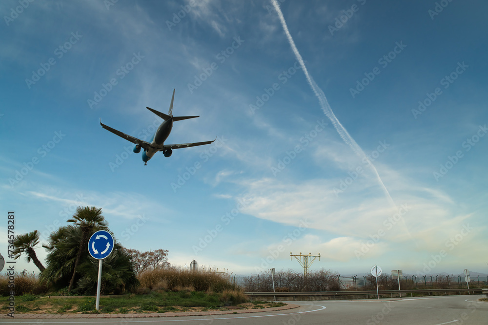 Silhouette of a civilian airplane in a blue sky and with a vapor condensation trail left by another plane, heading for landing at the airport. Silhouette of a civilian airplane in a blue sky and with a vapor condensation trail left by another plane, heading for landing at the airport.