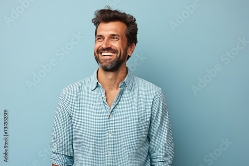 Portrait of a happy young man smiling at camera against blue background
