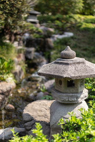 Jardin japones con linternas verticales de piedra gris, kasuga o yukimi