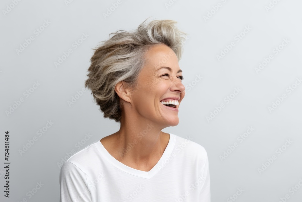 Portrait of happy senior woman with short grey hair laughing and looking up. Portrait of happy senior woman with short grey hair laughing and looking up.