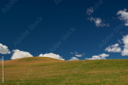 hill against the blue sky with clouds