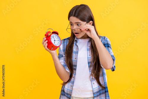 Teen girl has deadline. good morning. school time schedule. teen girl with alarm clock. Time ticking for a busy teen girl. teen girl check time at the clock while studying. lack of time