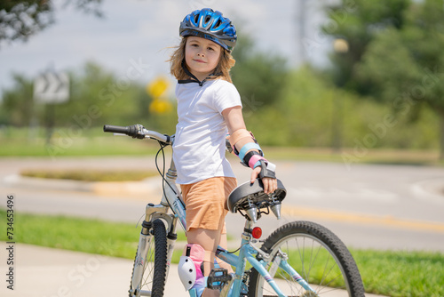 Kid learning to ride bike. Child riding bicycle. Little kid boy in helmet on bicycle along bikeway. Happy cute little boy riding bicycle. Child in the protective helmet for bike cycling on bicycle.