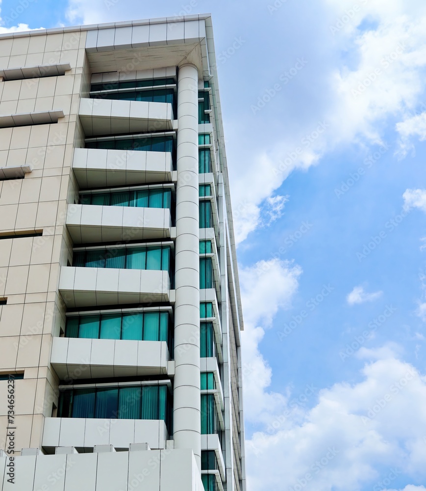 Towering buildings seen from the side against a blue sky background Towering buildings seen from the side against a blue sky background