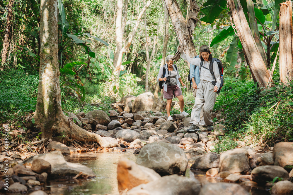 Obraz premium Young female backpacker group traveling in wild forest, Attractive girl traveler look around and explore while walk in nature wood with happiness and fun during holiday vacation trip.