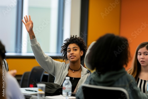 student raising hand to participate in class discussion