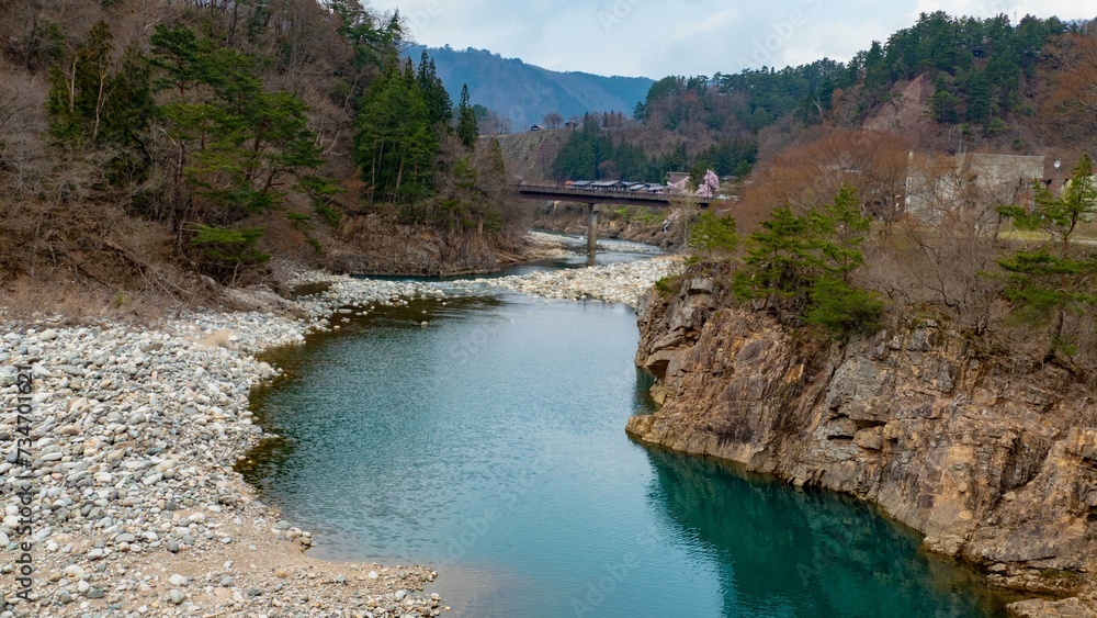Scenic view of a river flowing through forest near a Japanese village