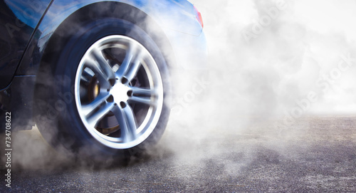 The wheels of the race car spin at speed on track and are covered with smoke, racing car drifting and burning tire , copy space , Car competition concept photo