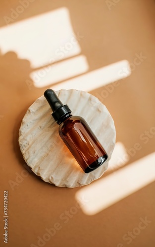 Brown glass cosmetic bottle on warm light pastel background