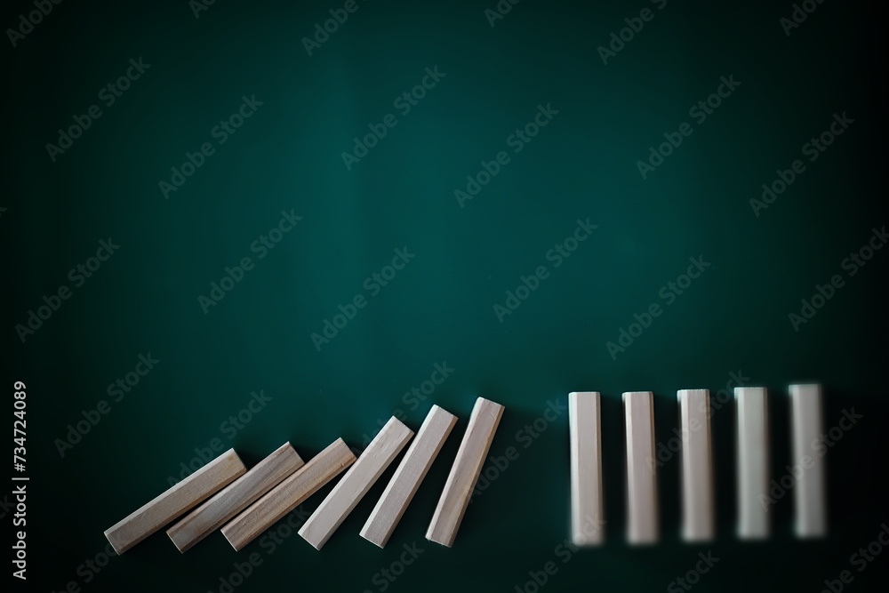 domino effect concept with wooden tiles blocked by hourglass with background domino effect concept with wooden tiles blocked by hourglass with background