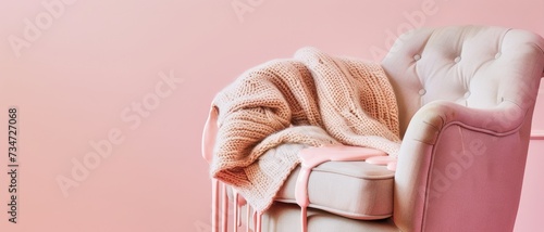 Cozy armchair with a knitted blanket and dripping pink paint  symbolizing comfort and creativity in home decor.