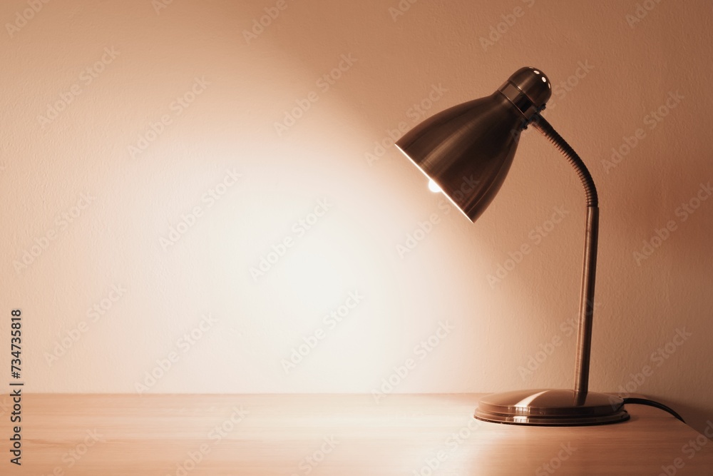 Lamp on the desk top, space for text. Trendy color of the year 2024 - peach fuzz