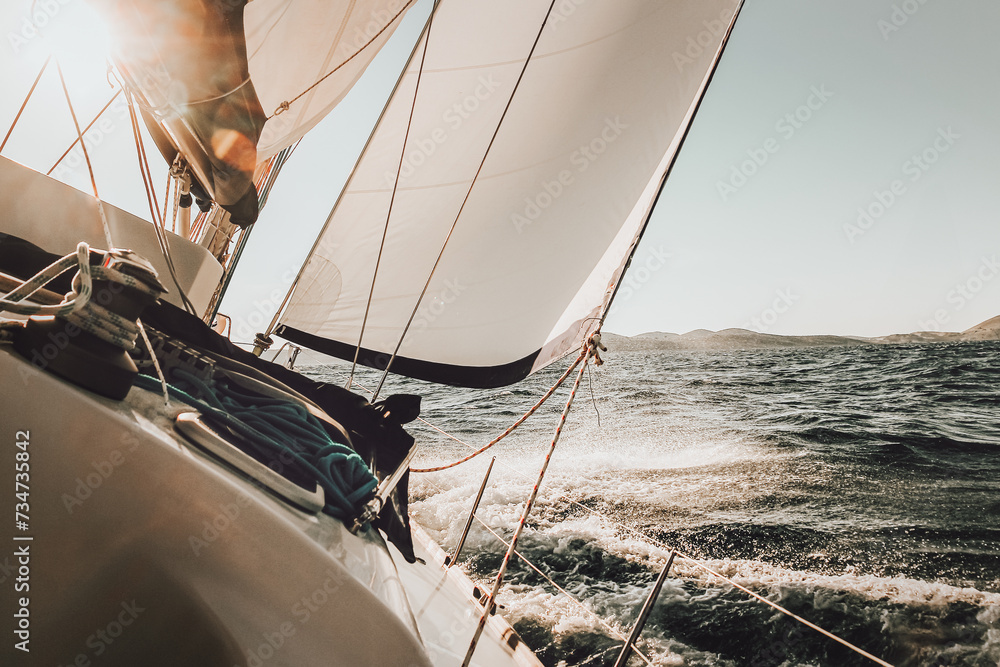 Fototapeta premium Yacht at sea, a sunset regatta. Tilted boat sailing on the ocean