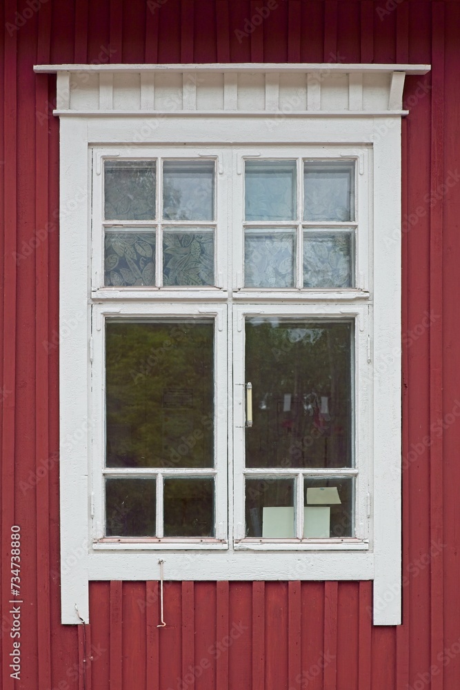 White framed window on old red painted wooden wall.