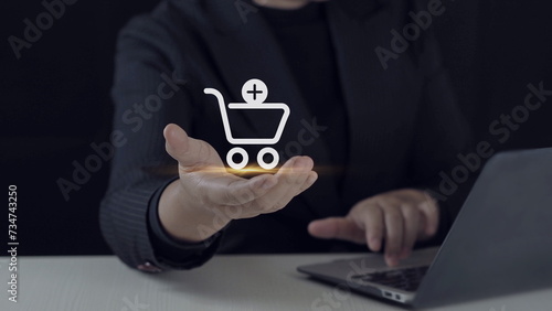 Business ecommerce concept. Person use laptop with online shopping cart icon for Internet shopping,shopping on the internet.