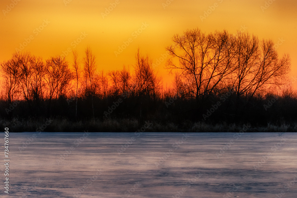 North-eastern European river after frosty winter. Porous ice began to melt, river is swollen, state of ice week before ice break (ice-boom). Aurora, sunrise colors on a spring moning