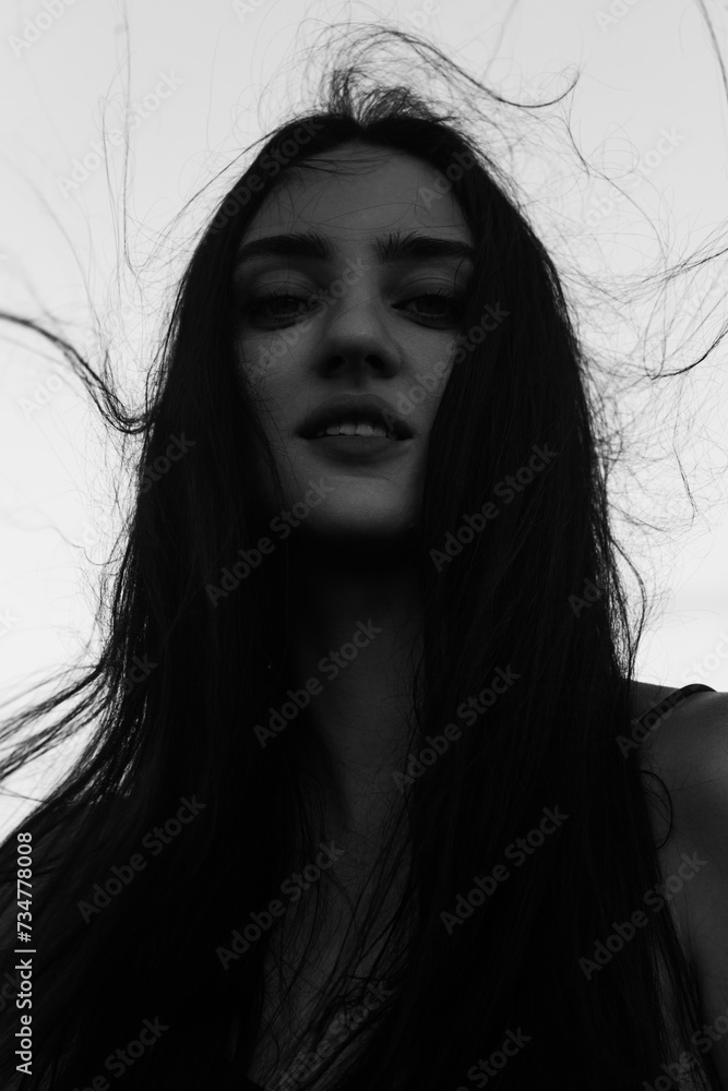 Closeup portrait of a beautiful girl with long hair standing in the wind on the street Closeup portrait of a beautiful girl with long hair standing in the wind on the street