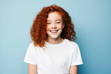 Radiant Laughter: 12-Year-Old Redhead with Curly Hair Laughing Against Bright Blue Wall