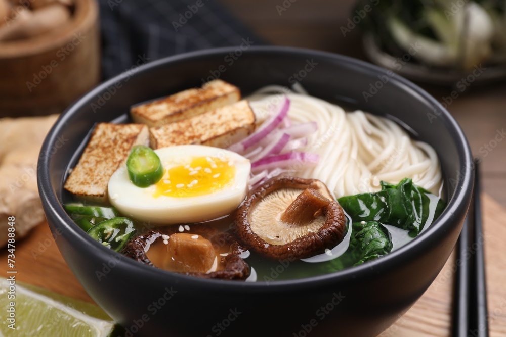Delicious vegetarian ramen in bowl on wooden table, closeup Delicious vegetarian ramen in bowl on wooden table, closeup