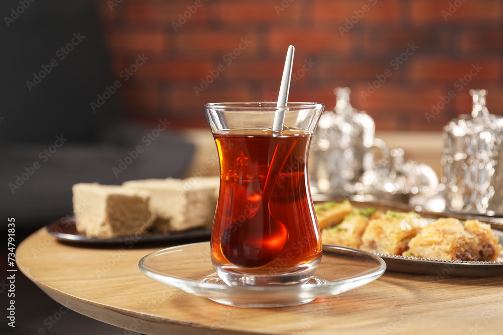 Traditional Turkish tea in glass and Eastern sweets on wooden table Traditional Turkish tea in glass and Eastern sweets on wooden table