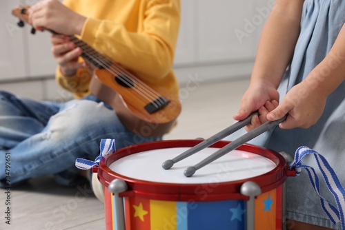 Little children playing toy musical instruments indoors, closeup photo