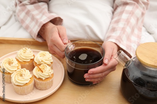 Woman with cup of hot drink in bed  closeup