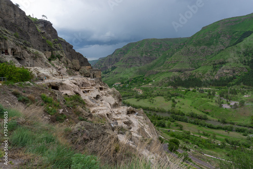 Day view of the caves in the mountain, river valley and blue sky. Vardzia is a cave monastery, an ancient rock-hewn town, was excavated in the Erusheti Mountain.