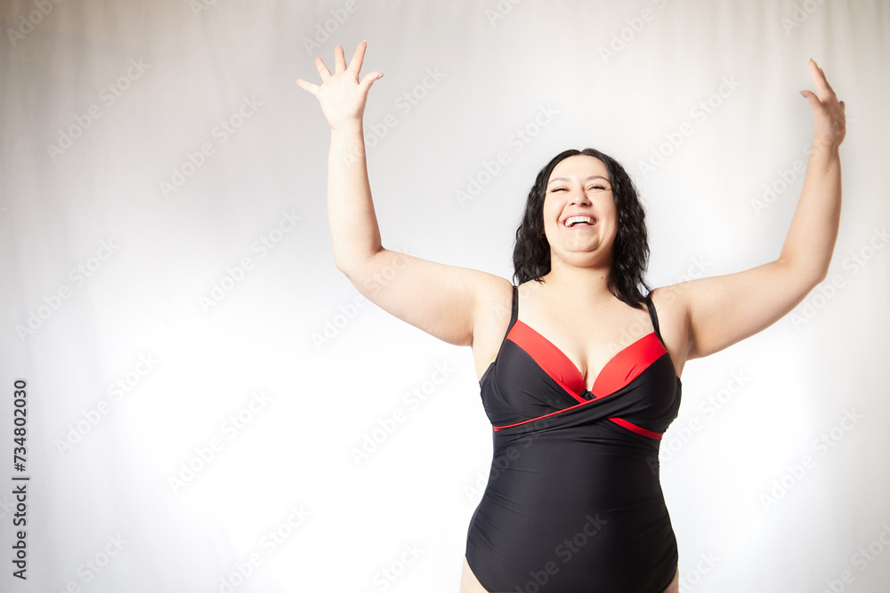 Happy attractive thick woman in swimsuit posing on white background. Body positive, photoshoot, selfie. Funny plus size model. Winner in Weight loss Happy attractive thick woman in swimsuit posing on white background. Body positive, photoshoot, selfie. Funny plus size model. Winner in Weight loss
