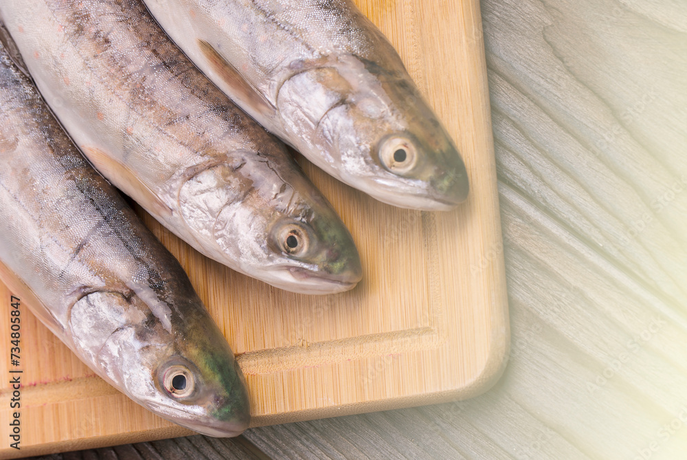 Fresh fish on the board. on the wooden background on sunlight Fresh fish on the board. on the wooden background on sunlight