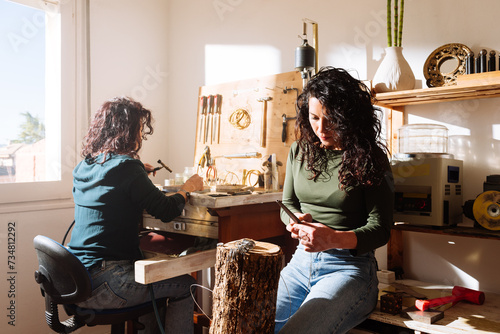 Female jewelers working in modern workshop together photo