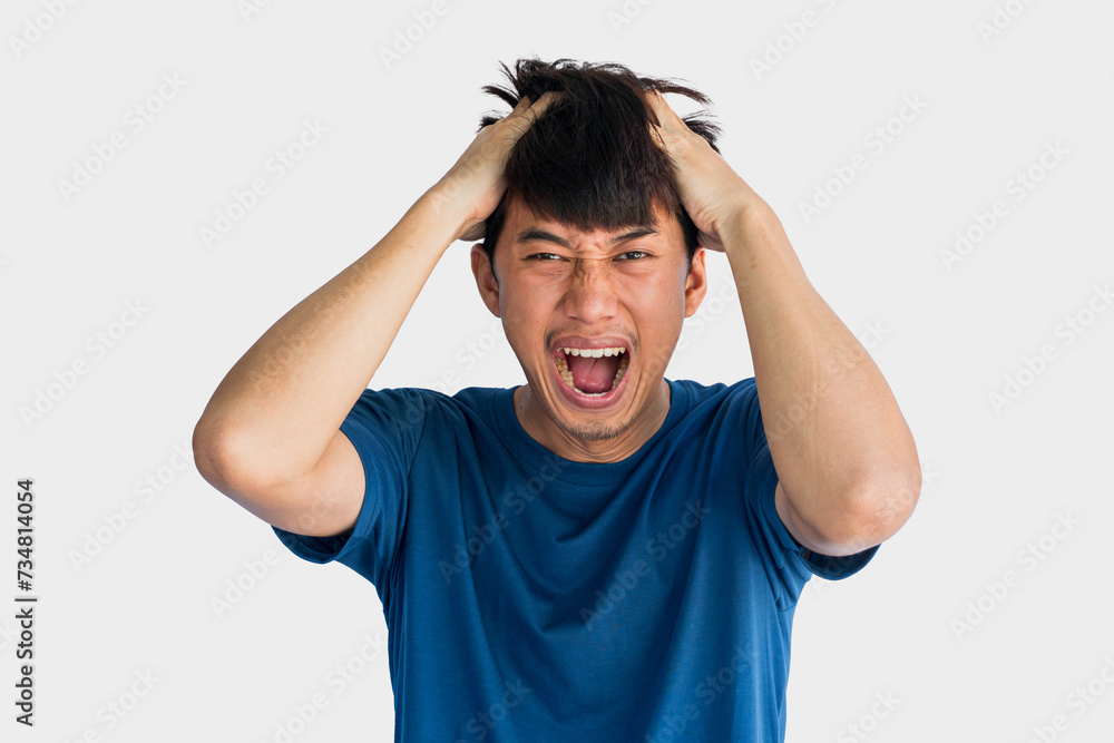 Naklejka premium Young Asian man in blue t-shirt who is angry holding his head with his hands isolated on gray background.
