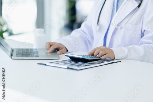 Asian female doctor working with laptop and health personal data in modern clinic  Healthcare and medical concept.