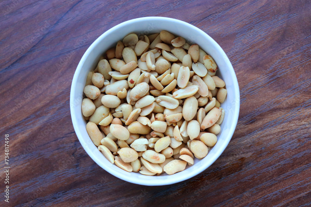 Roasted and salted Peanuts in a white bowl, also called groundnut, Shengdane, mungfali, and goober. Popular party snack. Copy Space. Roasted and salted Peanuts in a white bowl, also called groundnut, Shengdane, mungfali, and goober. Popular party snack. Copy Space.