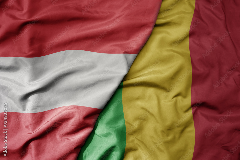 big waving national colorful flag of mali and national flag of austria .