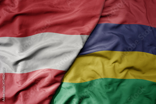 big waving national colorful flag of mauritius and national flag of austria .