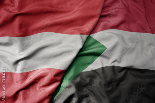 big waving national colorful flag of sudan and national flag of austria .