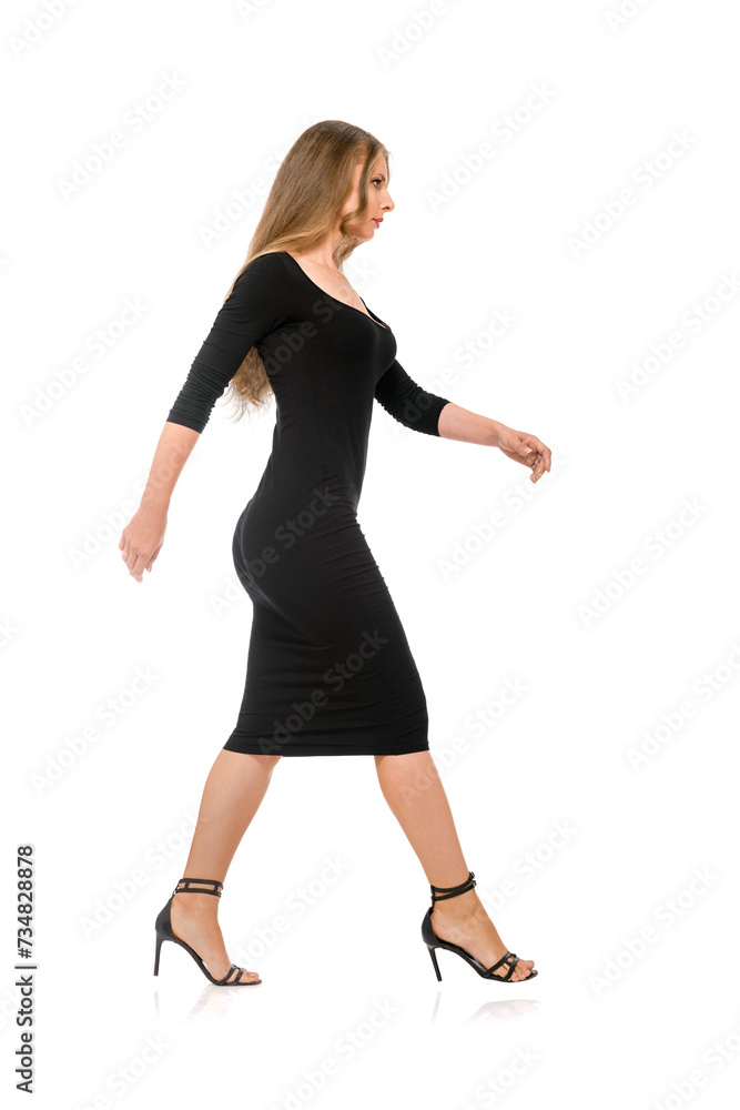 Side view of young slender woman walking in black dress and high heel shoes on white background Side view of young slender woman walking in black dress and high heel shoes on white background
