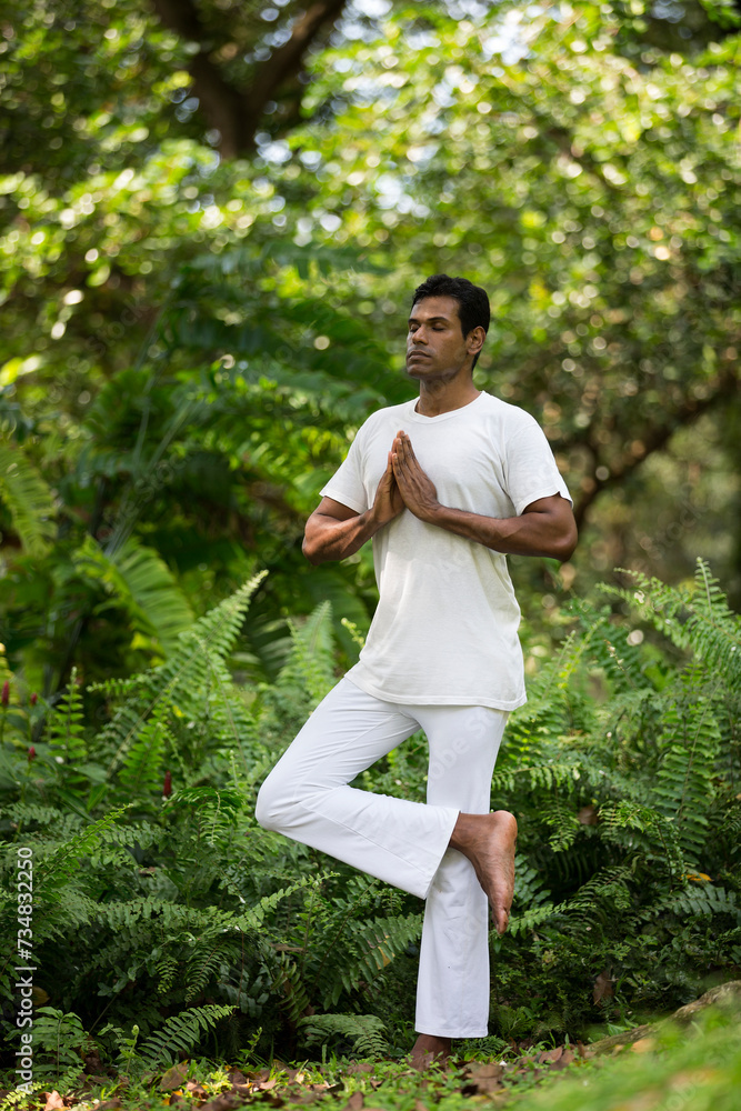 Indian man doing yoga exercise in a forest Indian man doing yoga exercise in a forest